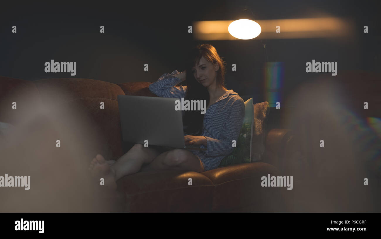 Woman on sofa in living room Banque D'Images