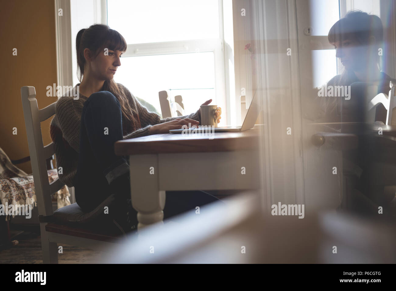Woman using laptop at home Banque D'Images