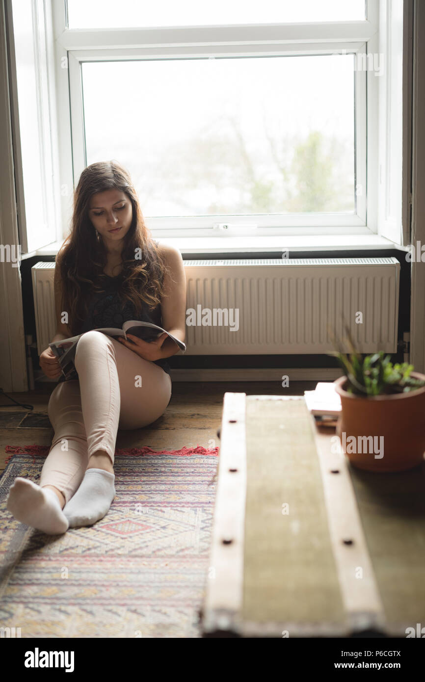 Woman Reading book at home Banque D'Images