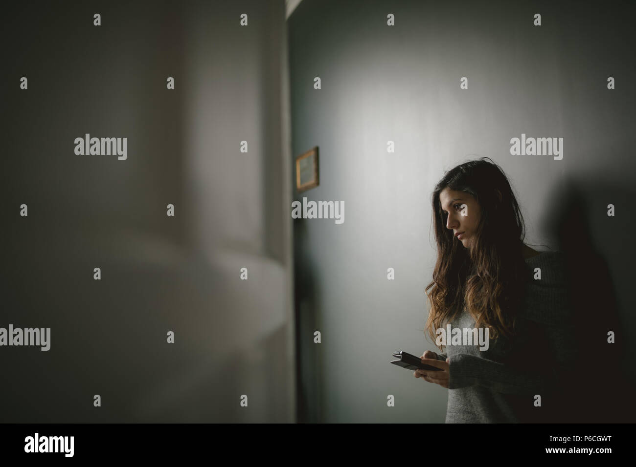 Thoughtful woman with mobile phone Banque D'Images