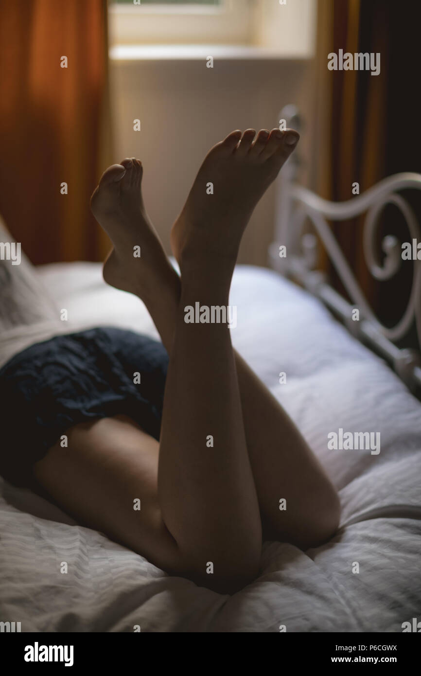 Woman lying on bed at home Banque D'Images