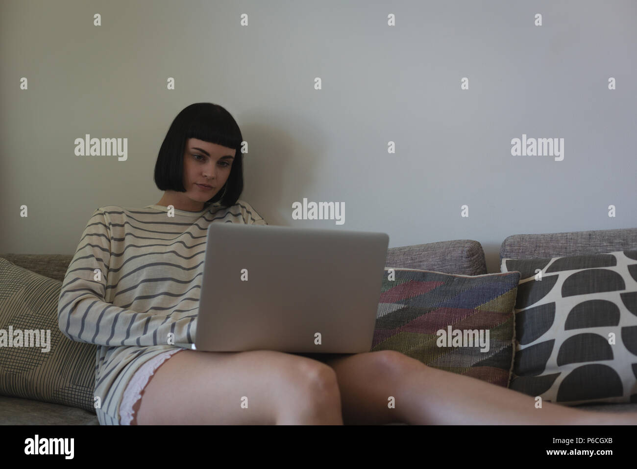 Woman using laptop in living room Banque D'Images