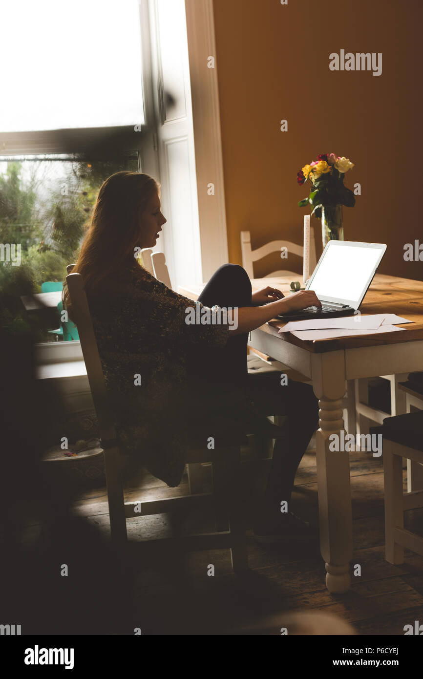 Woman using laptop at home Banque D'Images