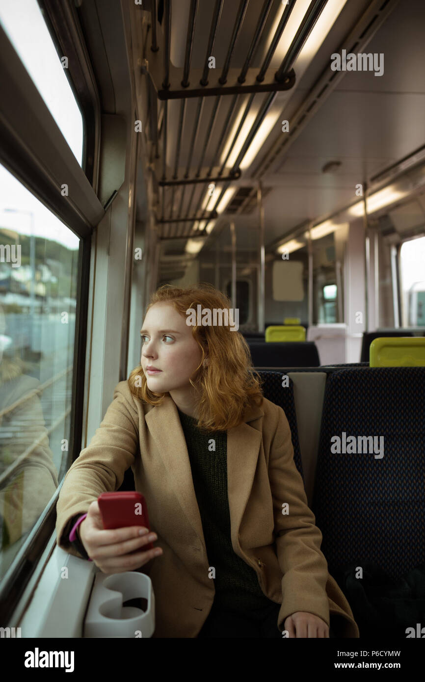 Red hair woman tout en utilisant son mobile Banque D'Images