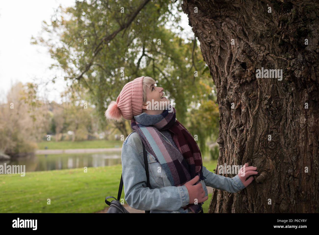 Femme en vêtements d'hiver à la recherche de l'arbre à Banque D'Images