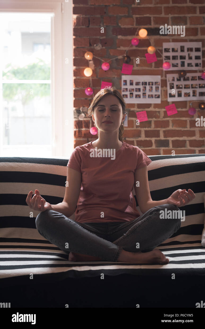 Female executive performing yoga in office Banque D'Images