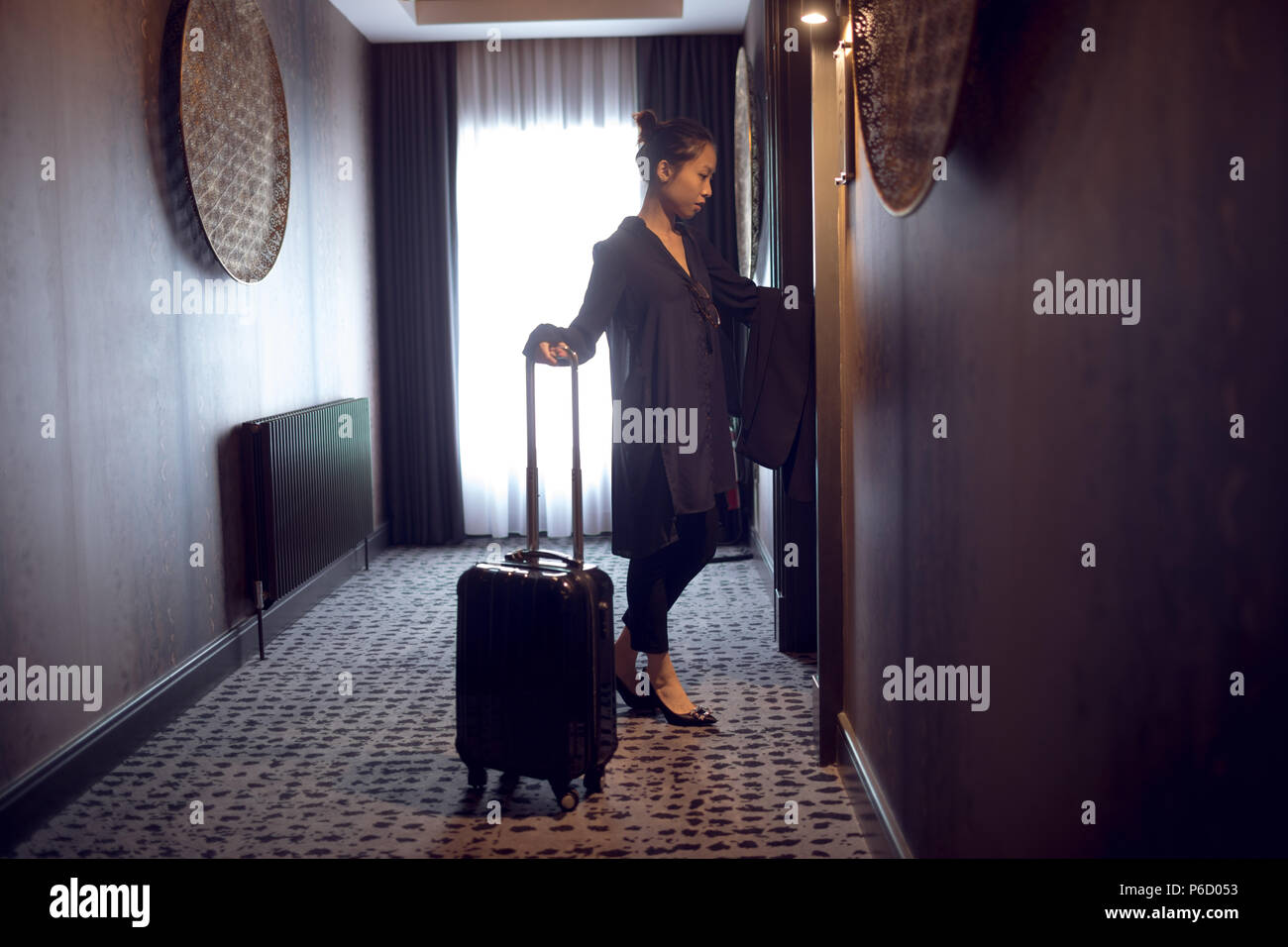 Femme d'entrer dans la chambre d'hôtel Banque D'Images