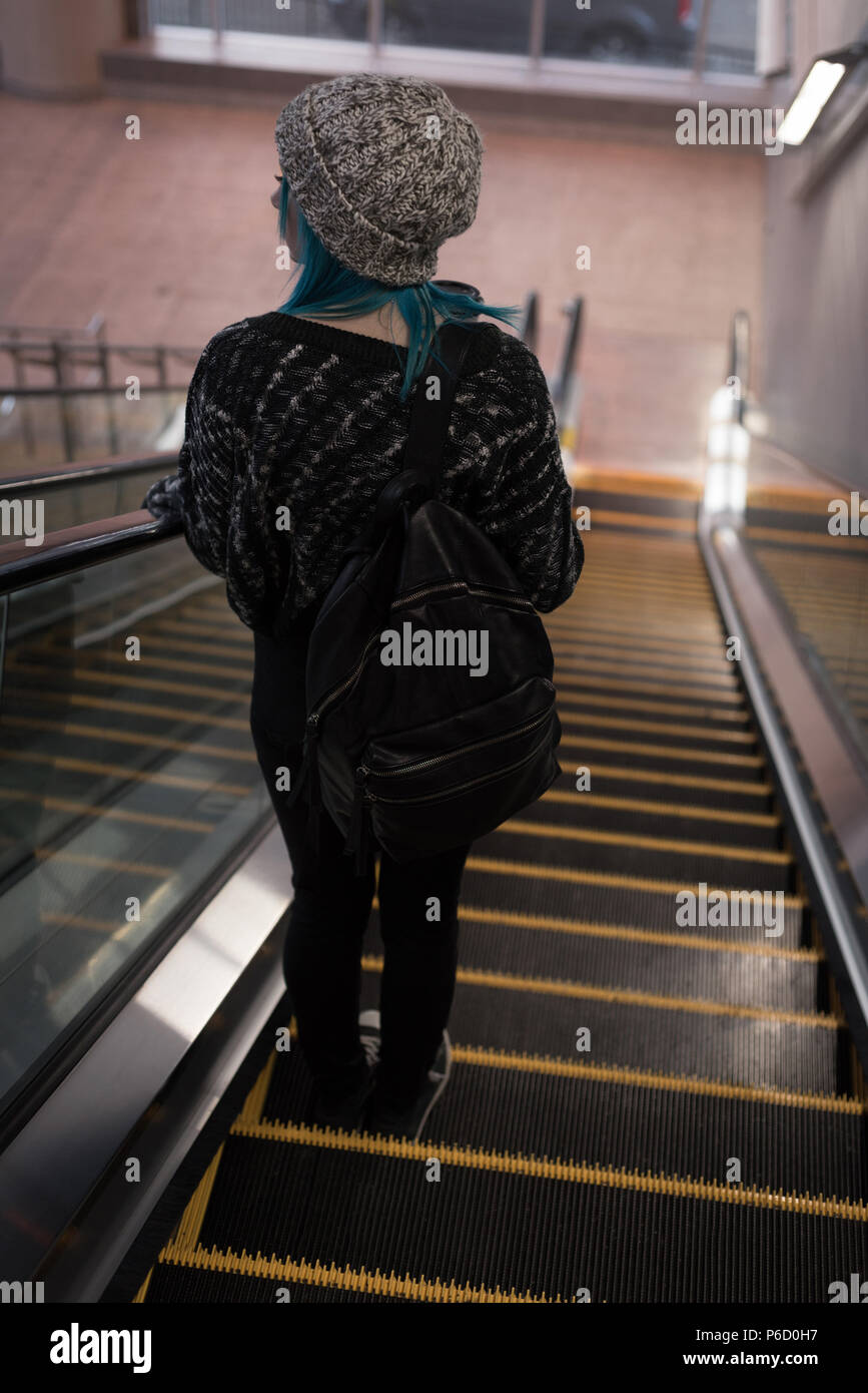 Femme en descente d'un escalier mécanique à la station Banque D'Images