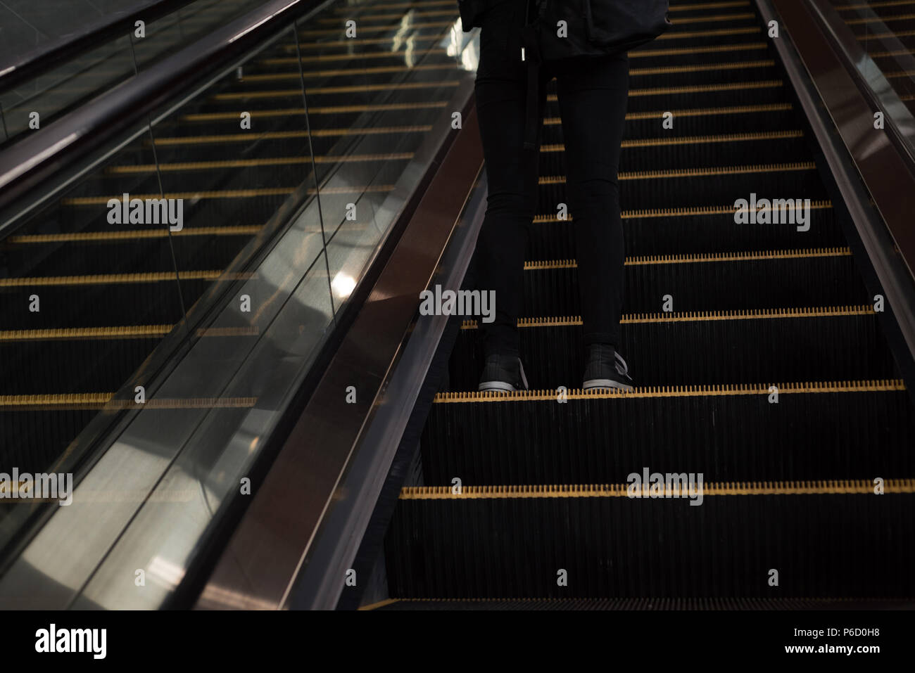 Femme debout d'un escalier mécanique à la station Banque D'Images