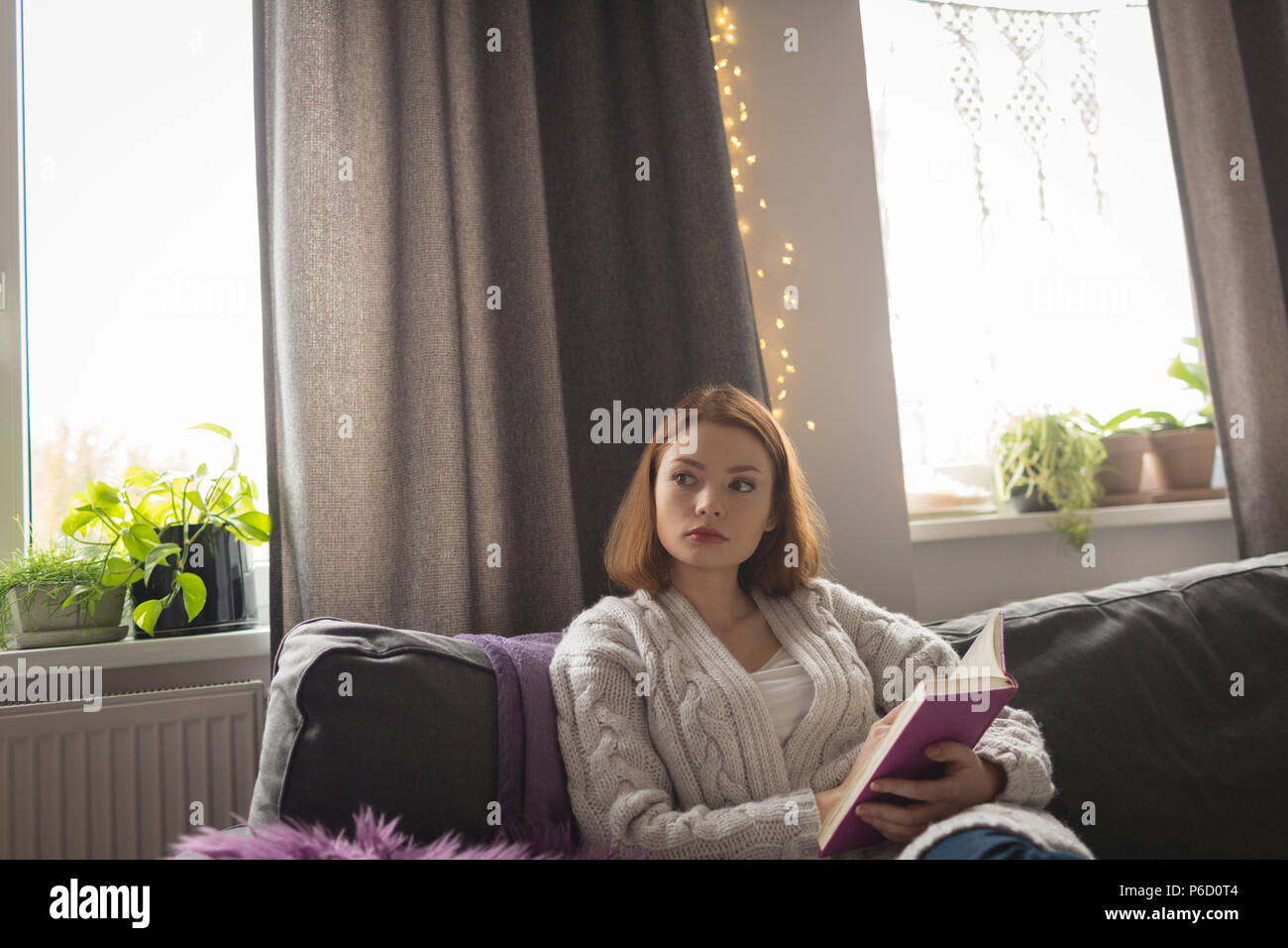 Femme écrivant sur un journal dans la salle de séjour à la maison Banque D'Images