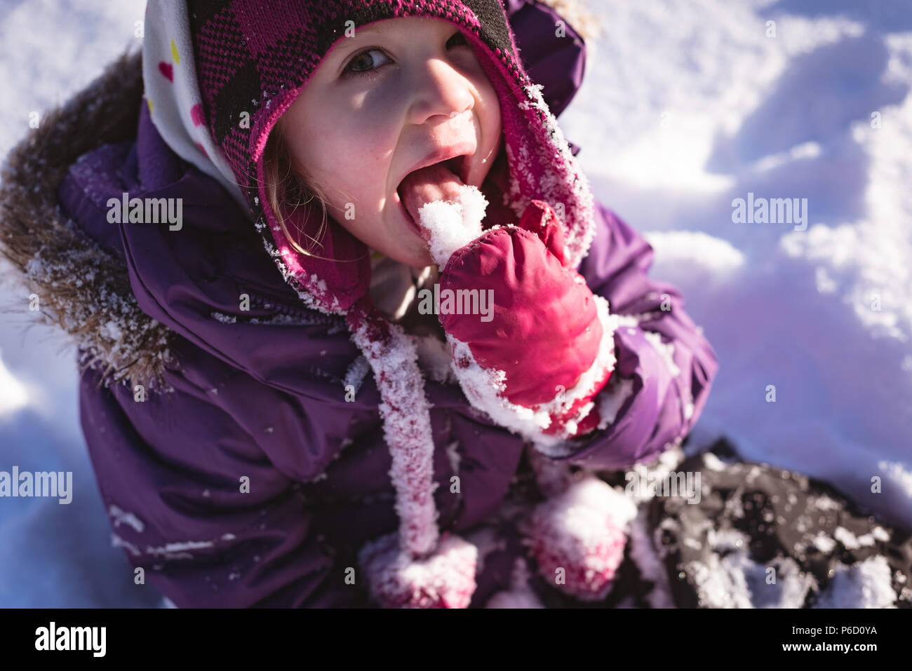 Portrait of cute girl licking snow Banque D'Images