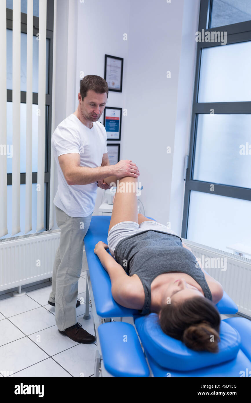 Physiothérapeute massage des jambes donnant à la femme Banque D'Images