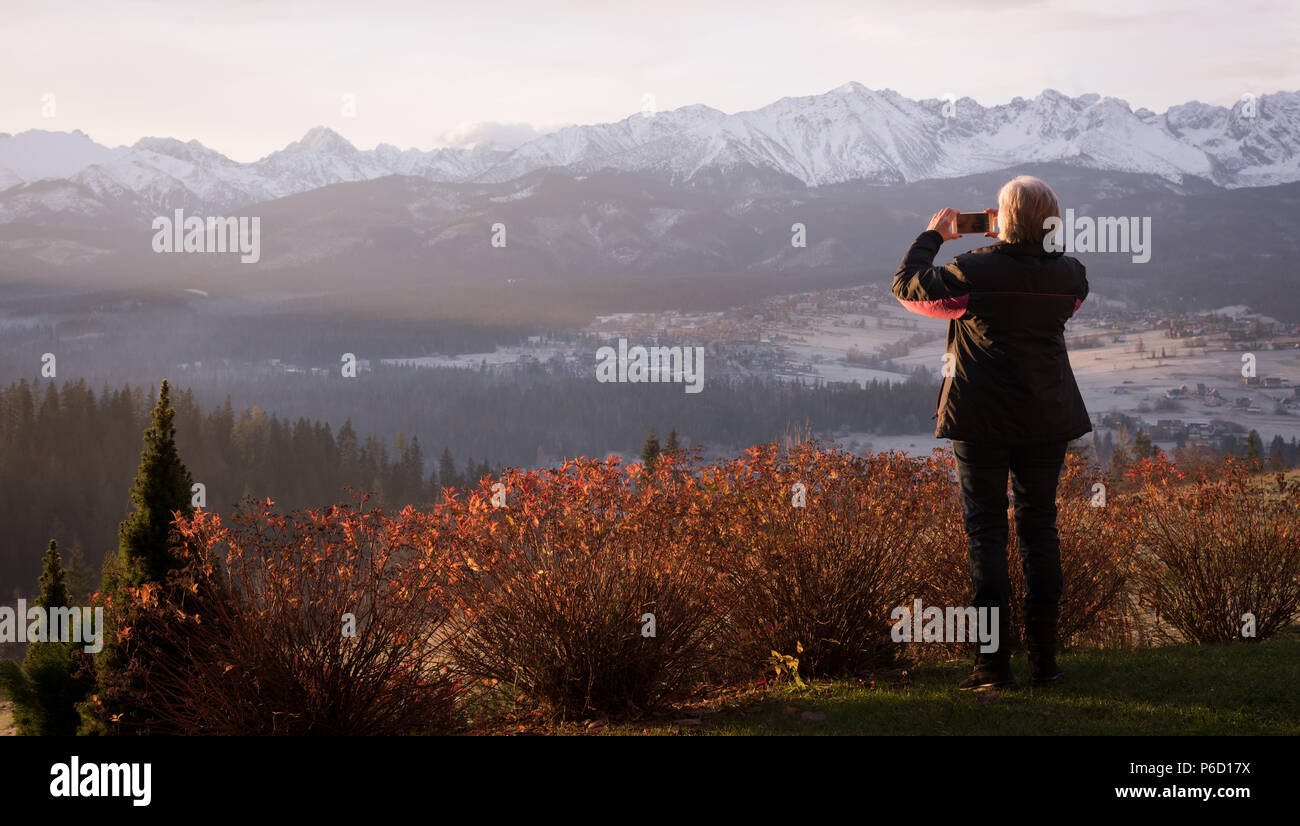 Rear view of woman taking picture with mobile phone Banque D'Images