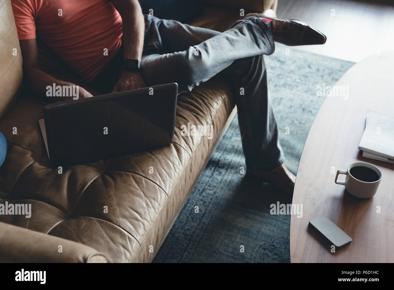 Businessman using laptop on a sofa Banque D'Images