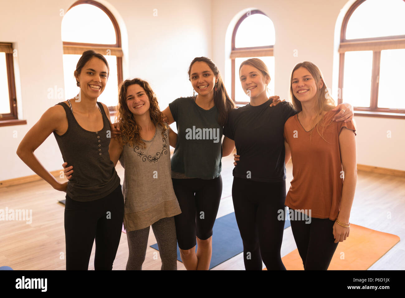 Groupe de femmes se tenant ensemble avec bras autour de Banque D'Images