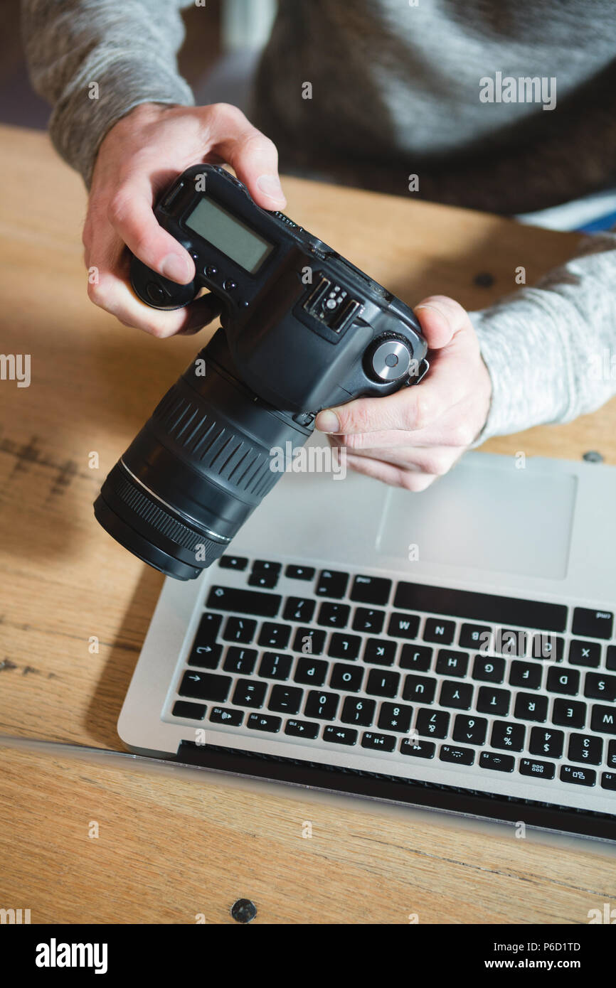 L'homme à l'aide d'un appareil photo numérique à la maison Banque D'Images