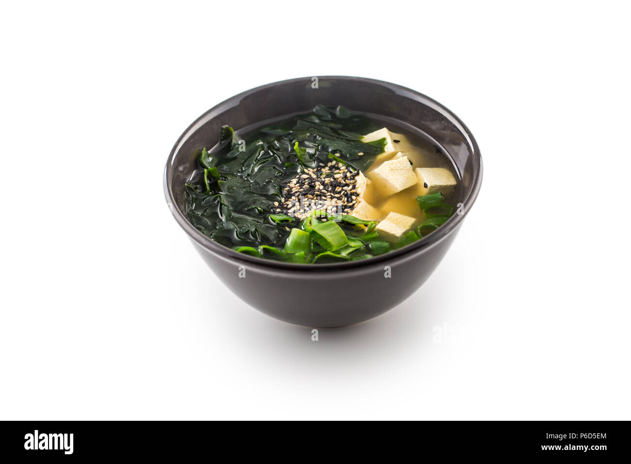 Le miso soupe japonaise traditionnelle avec du tofu et algues jeune oignon isolé sur blanc. Banque D'Images