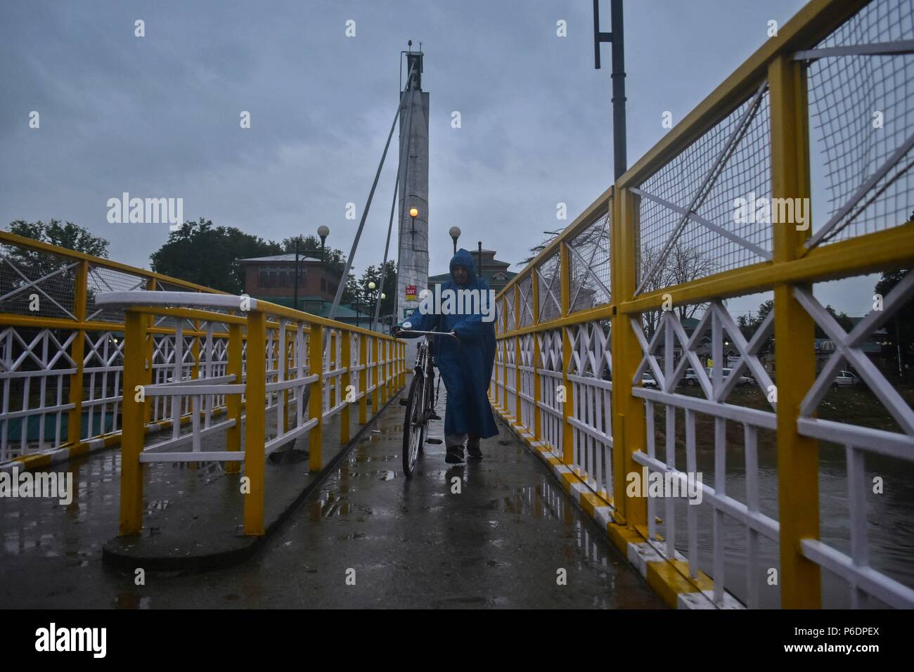 Un homme marche du cachemire dans une forte pluie à Srinagar. Une inondation alerte a été déclenchée au Cachemire à la suite de pluies continues depuis mercredi. L'irrigation et la lutte contre les inondations Ministère de l'État a émis l'alerte dans plusieurs endroits après que l'eau a traversé le danger marque dans différents affluents à Srinagar, Cachemire indien. Banque D'Images