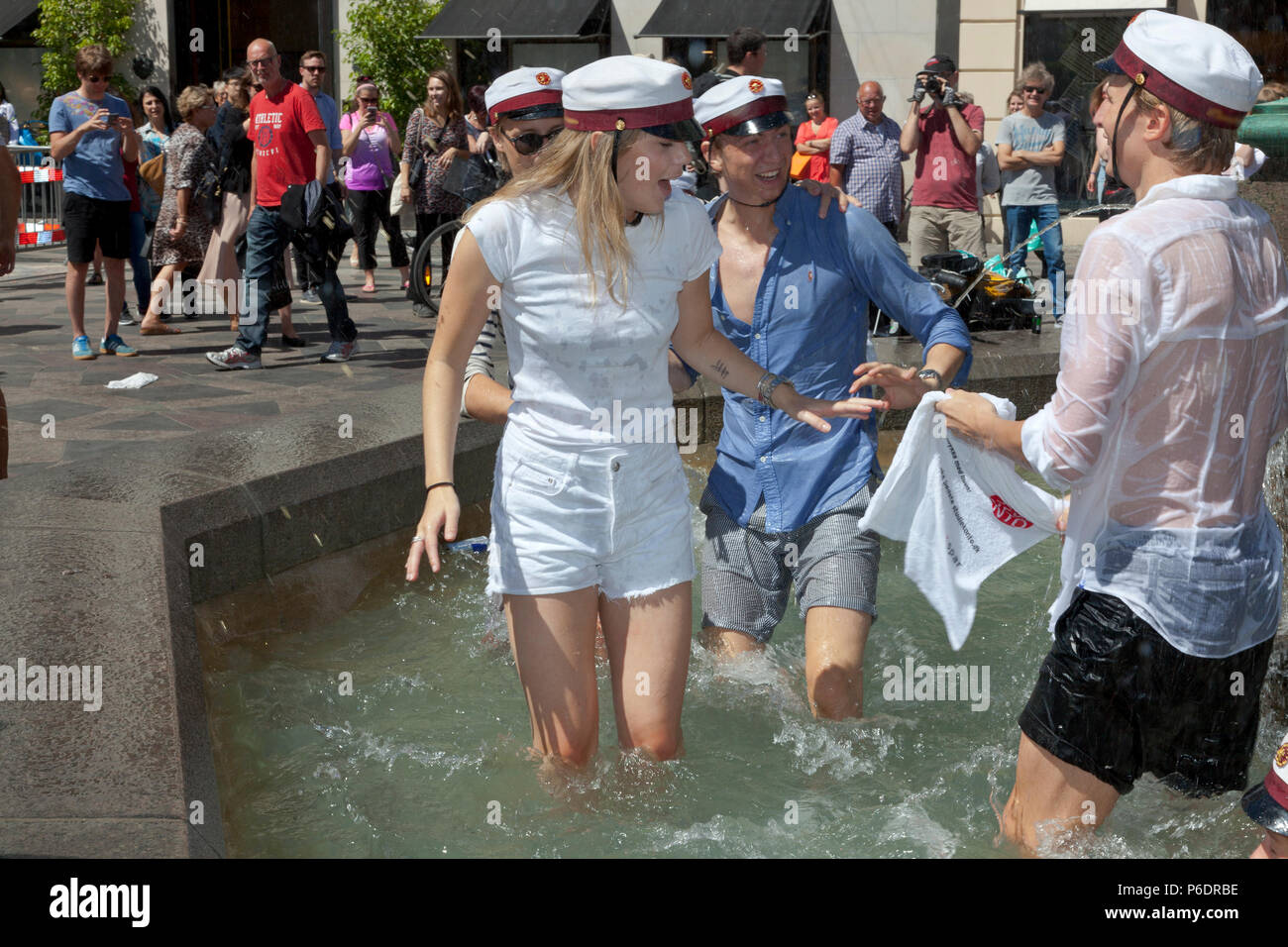 Copenhague, Danemark. 29 juin 2018. Les serviettes gratuites et sponsorisées provenant d'une banque à proximité sont les plus bienvenues après le plongeon. Les étudiants danois célèbrent leur lycée, la graduation de l'école de grammaire et prennent le plongeon. Une danse et un plongeon ou une plongée dans l'eau froide de la fontaine Stork (Storkespringvandet) sur la rue piétonne, Stroeget, est un élément traditionnel le jour de la célébration pour les étudiants diplômés du Grand Copenhague. Elle fait souvent partie de la longue tournée en camion épuisante et pleine d'esprit qui visite le domicile de chaque étudiant pour des rafraîchissements. Crédit : Niels Quist/Alay Live News Banque D'Images