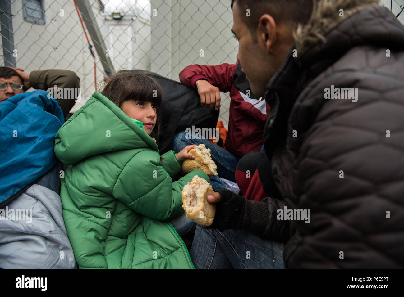 Les gens mange sandwich près de la frontière en attendant de traverser la frontière Greece-Macedonia au camp de réfugiés de fortune près du village grec o Banque D'Images