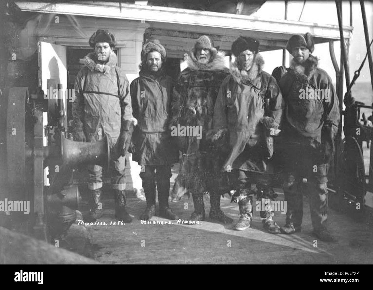 . Anglais : traîneaux à chiens ('Mhuissiers'), cinq hommes de l'Arctique en robe, ca. 1910 . Anglais : Légende sur l'image : Mushers, Alaska PH Coll 247,343 quelqu'un qui conduit, ou 'mushes", une équipe de chien est connu comme un musher. Le mot vient probablement du mot français 'marcher', qui signifie "marcher". Sujets (LCTGM) : Vêtements de fourrure ; & dress--Alaska ; hommes--sujets de l'Alaska (LCSH) : Mushers--Habillement--Alaska ; vêtements pour temps froid--Alaska . vers 1910 39 chiens de traîneaux à chiens (""), cinq hommes de l'Arctique en robe, ca 1910 THWAITES (308) Banque D'Images
