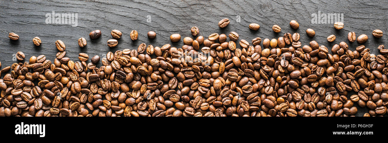 Les grains de café torréfiés sur table en bois. Vue d'en haut. Banque D'Images