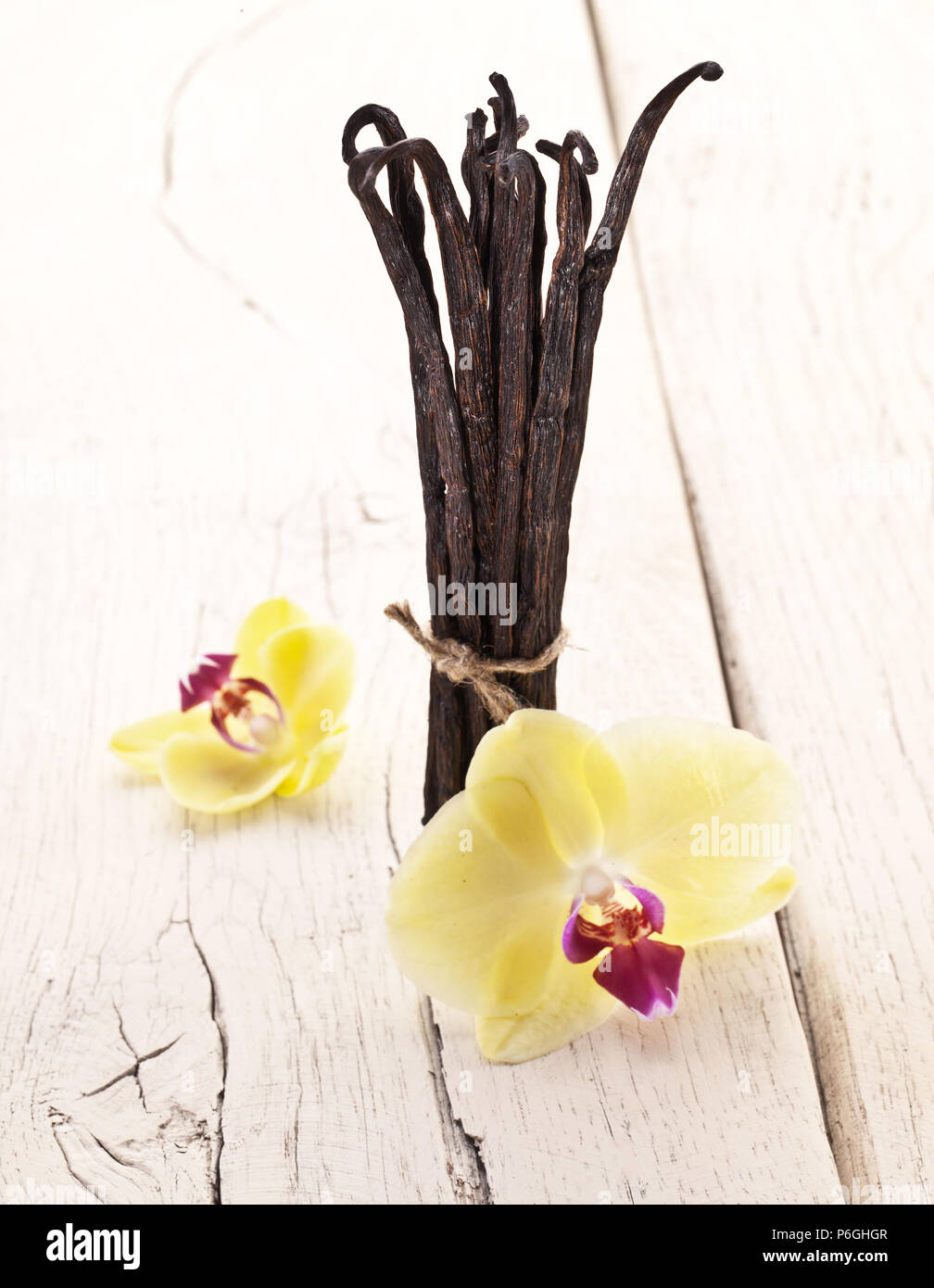 Fruits séchés et de vanille vanille orchidée Fleurs Fond en bois blanc. Banque D'Images