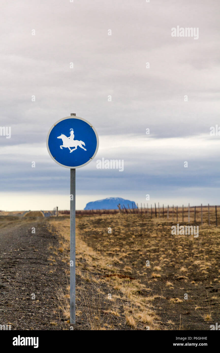 Vertical image de panneau routier à l'est de Reykjavik, Islande. Panneau bleu rond blanc a silhouette d'un cavalier sur un cheval au galop. Banque D'Images