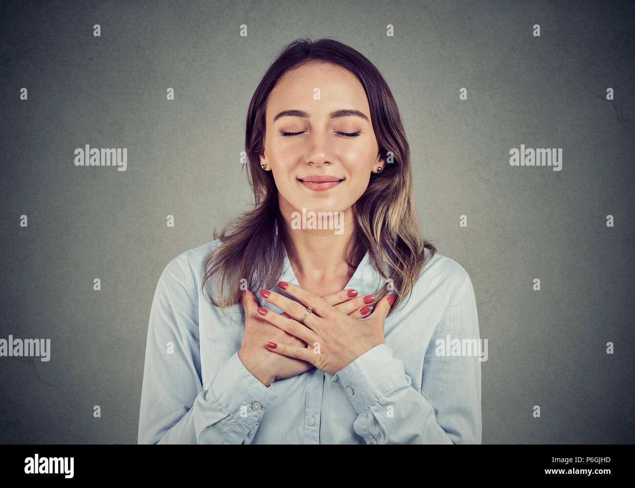 Femme avec les yeux fermés La main reste toujours sur la poitrine près de cœur, montre la bonté, exprime des émotions sincères, être gentil. Le langage du corps sentiments concept Banque D'Images