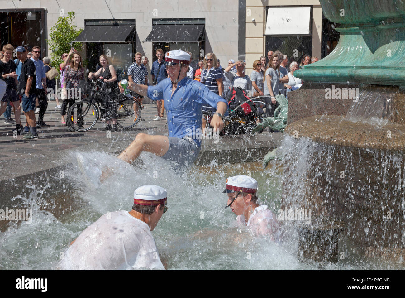 Les élèves heureux de célébrer leur diplôme du secondaire et de faire le saut dans l'eau froide de la fontaine, Stork Storkespringvandet, à Copenhague Banque D'Images