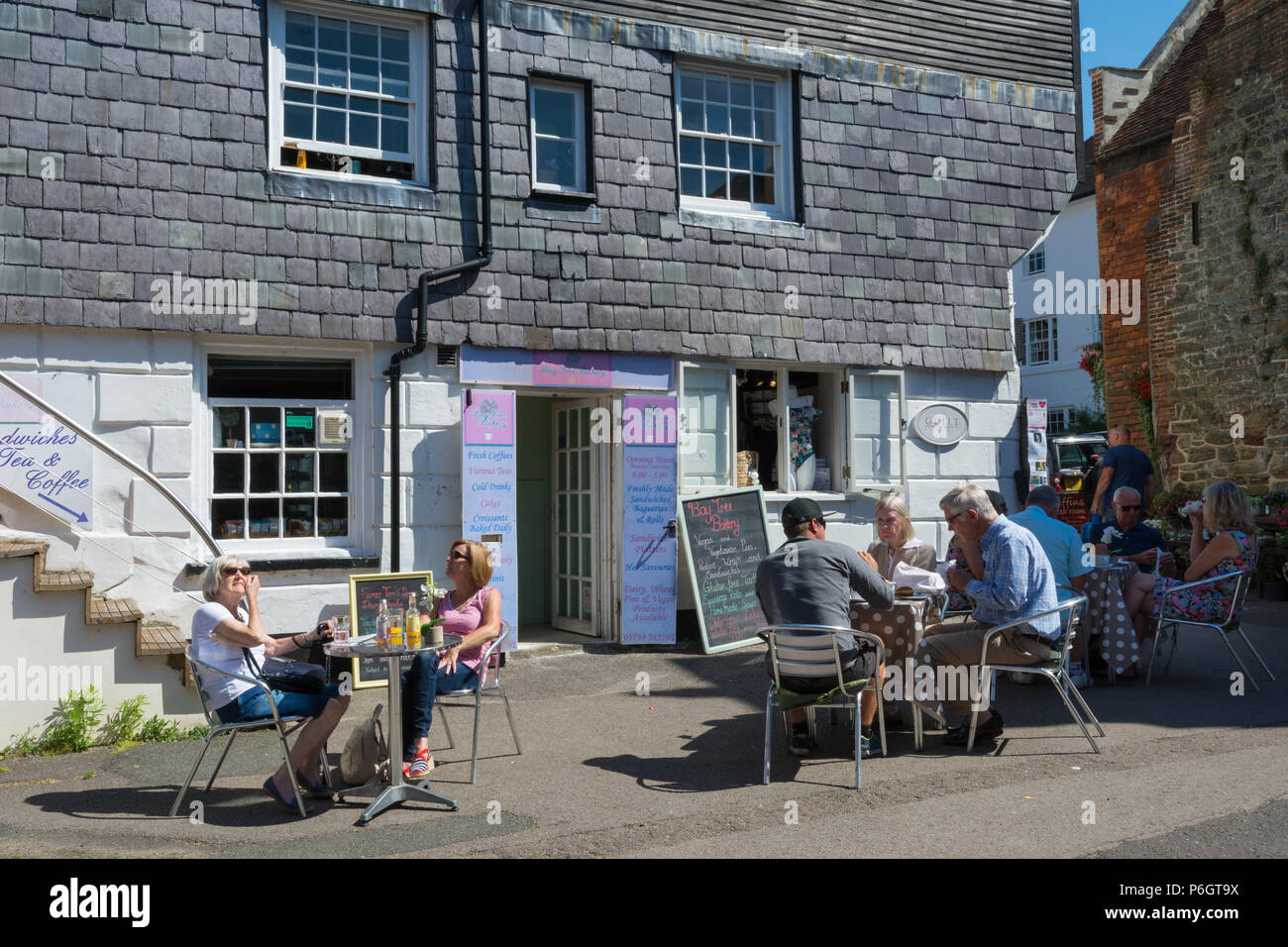 Les visiteurs assis à l'extérieur d'un café et prendre un verre dans l'ancienne boulangerie shopping arcade dans la pittoresque ville de marché de Petworth dans West Sussex, UK Banque D'Images