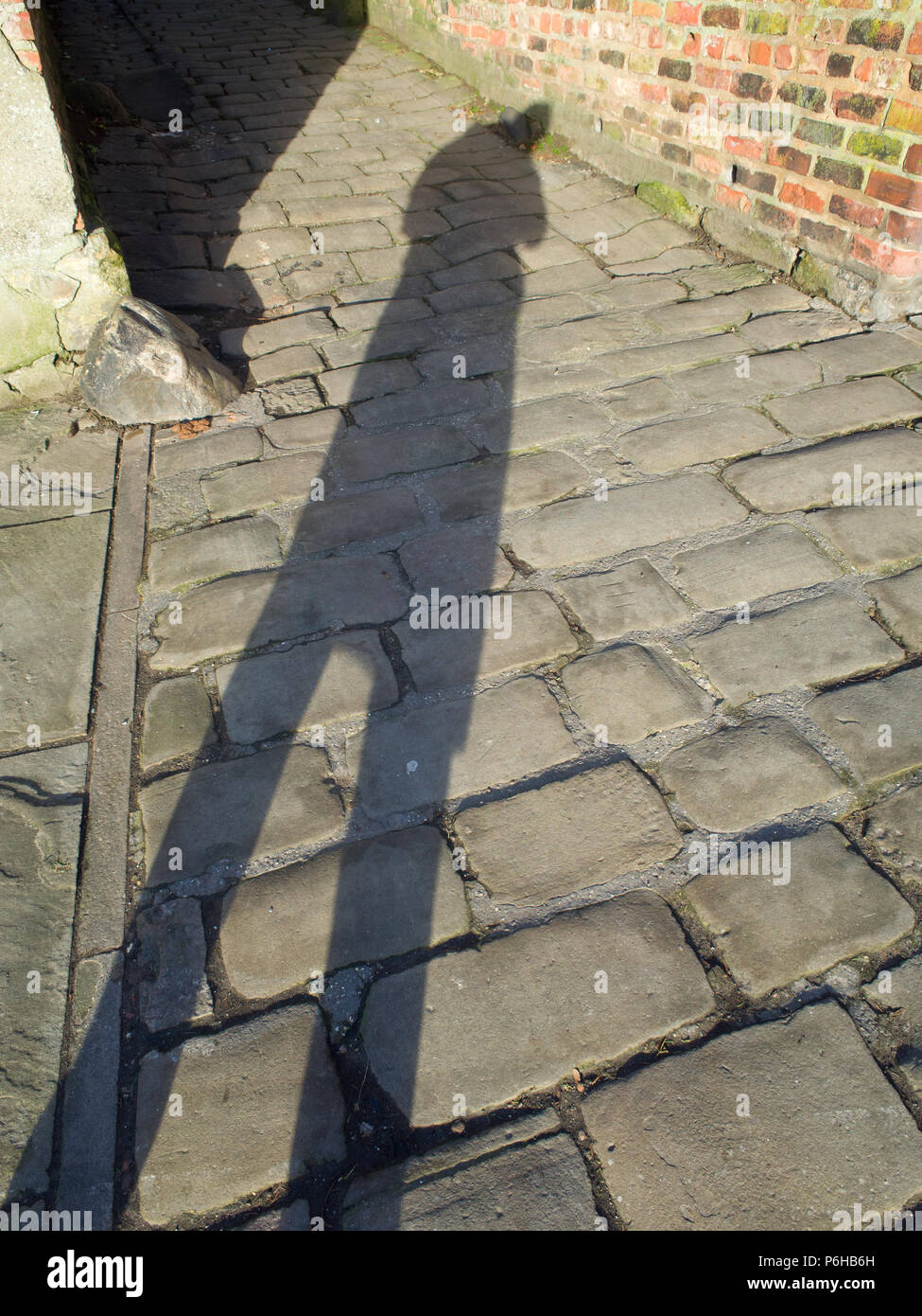 Long Shadow Cast sur une rue pavée Banque D'Images