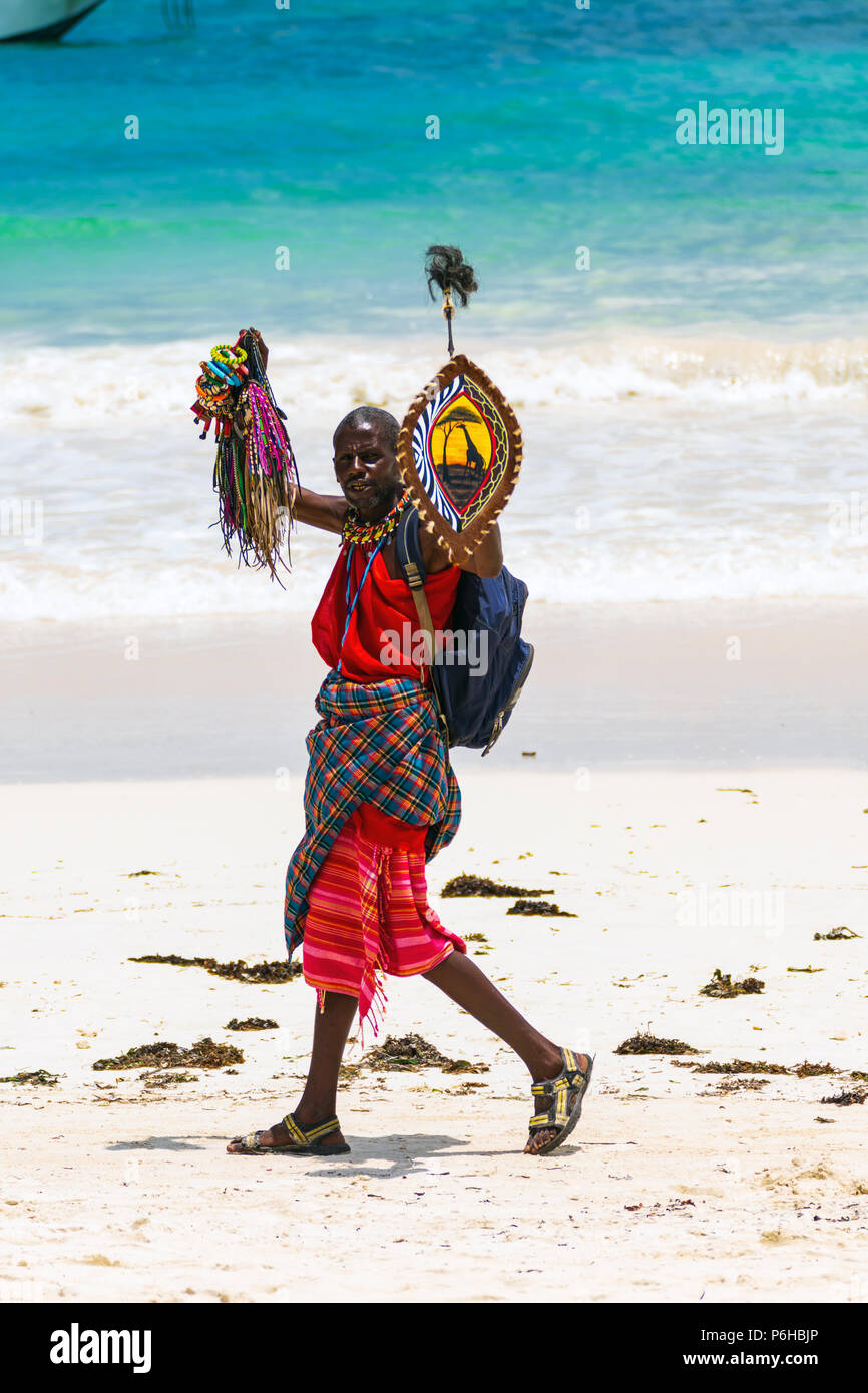 Diani Beach, Mombasa, Kenya - 10.30.2017 : un seul homme kenyan noir portant des vêtements Masai traditionnelle en essayant de gagner sa vie en vendant des souvenirs sur Banque D'Images