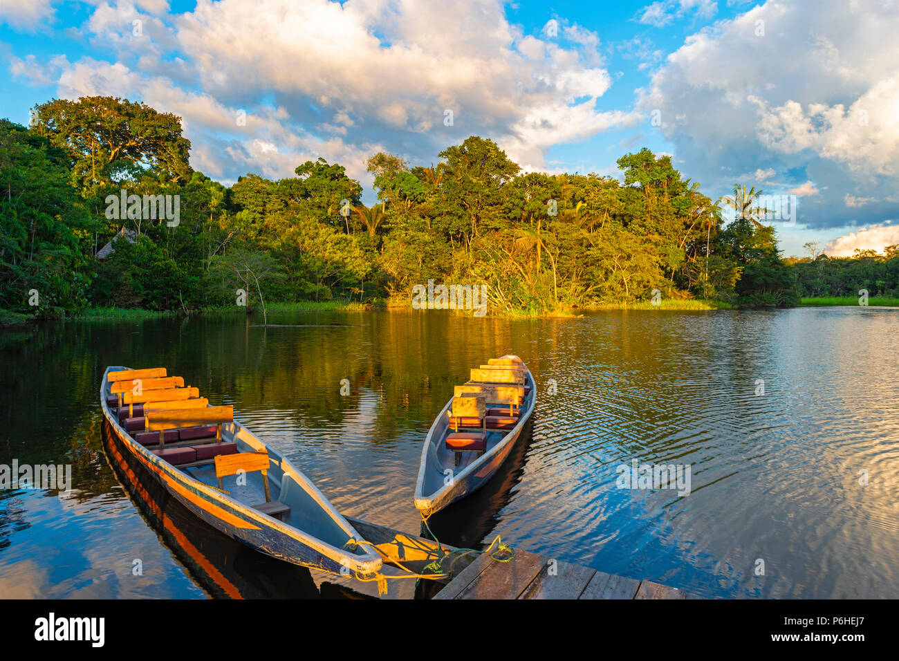 Deux canots en bois traditionnel au coucher du soleil dans le bassin de l'Amazone avec la forêt tropicale à l'arrière-plan, le Parc national Yasuni, en Equateur. Banque D'Images