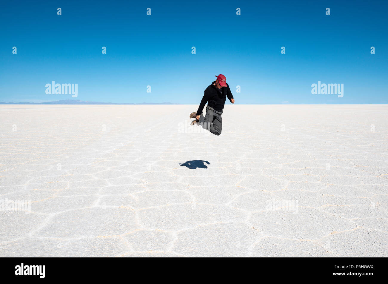 Self Portrait avec minuterie d'un jeune homme adulte sautant dans l'Uyuni Salt Télévision à haute altitude dans les montagnes des Andes boliviennes, la Bolivie. Banque D'Images Self Portrait avec minuterie d'un jeune homme adulte sautant dans l'Uyuni Salt Télévision à haute altitude dans les montagnes des Andes boliviennes, la Bolivie. Banque D'Images