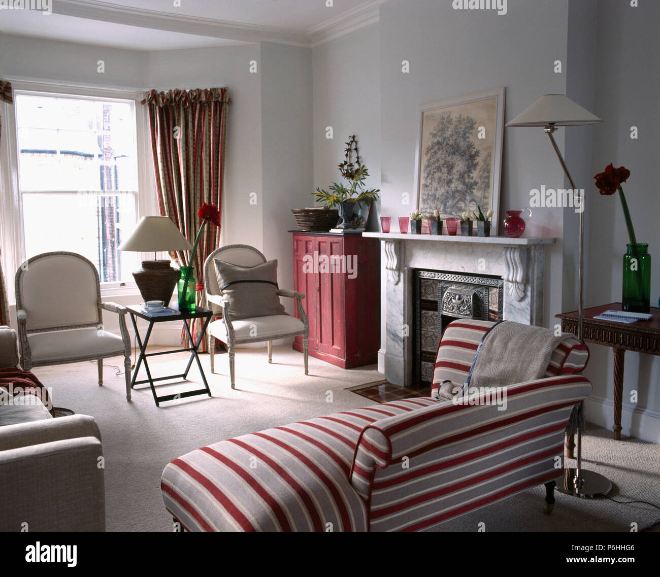 Red striped chaise longue et en ville-Chambre salon avec une cheminée en marbre Banque D'Images