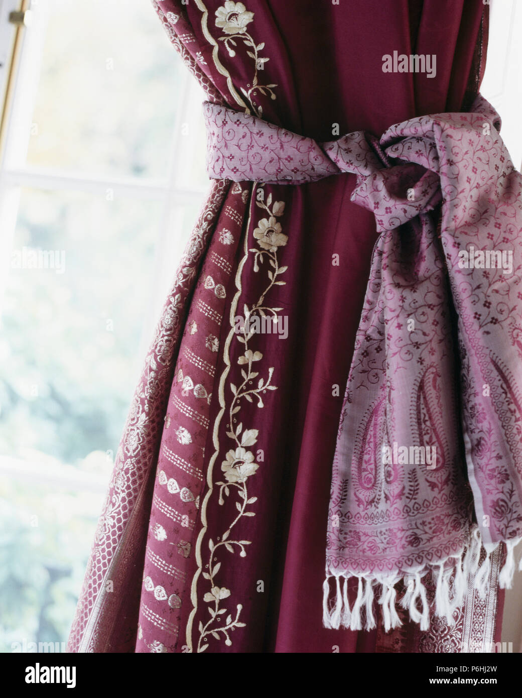 Close-up de rideau de soie rouge avec bordure brodé mauve et cravate soie-retour Banque D'Images