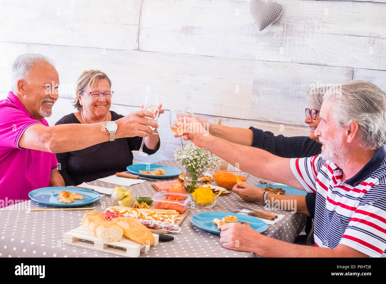 Groupe de personnes âgées deux familles célèbrent ensemble boire du vin et manger au déjeuner à la maison. senior adult caucasian personnes s'amuser et profiter de sa retraite li Banque D'Images