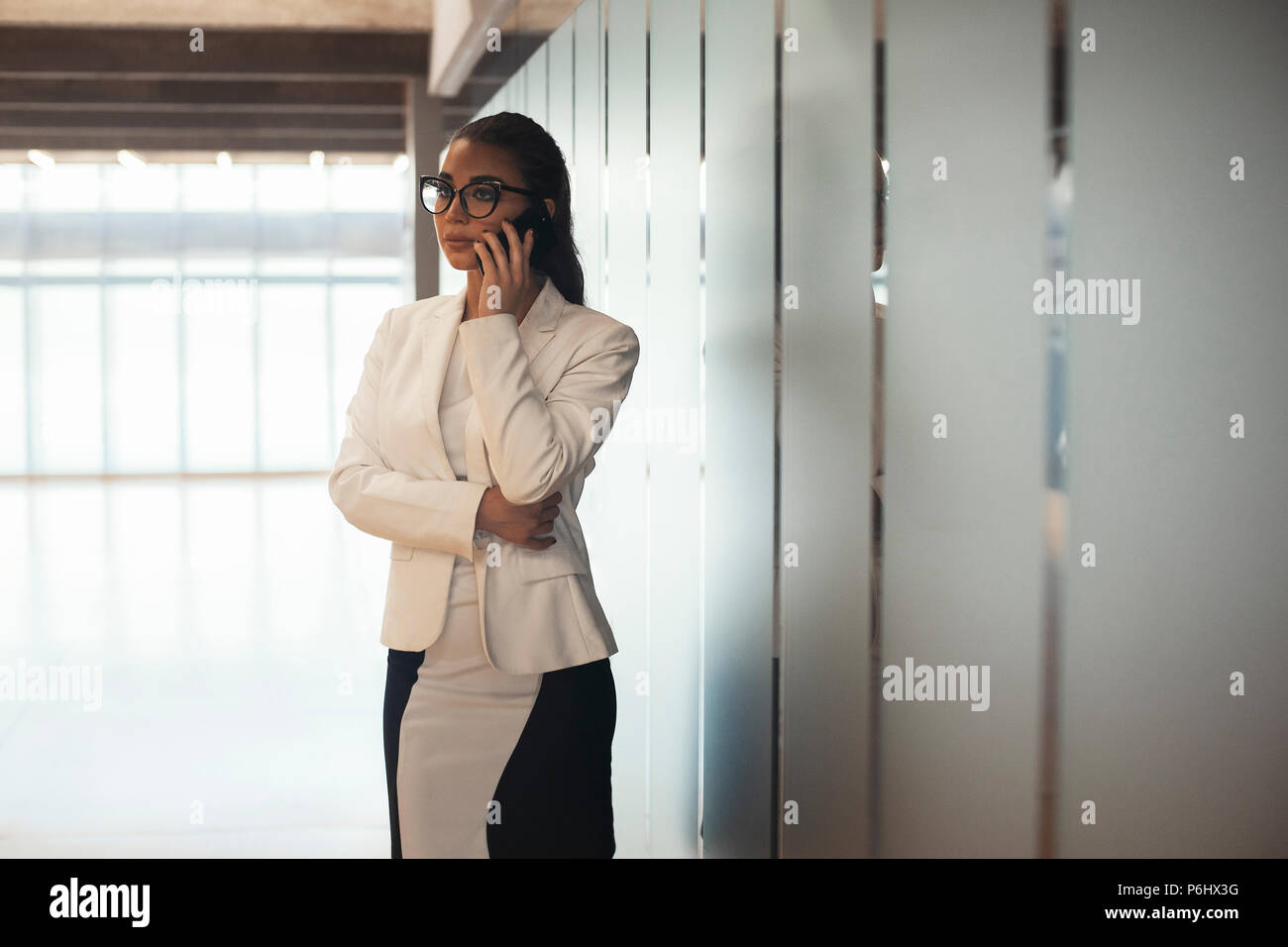 Jeune femme brune à lunettes d'affaires femme parlant par téléphone mobile  Photo Stock - Alamy