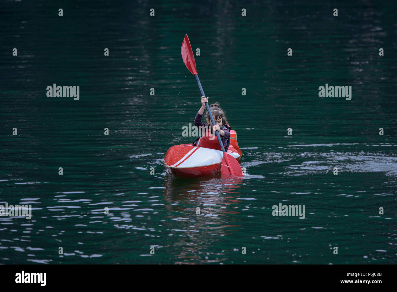 Les jeunes adolescentes gère activement un kayak sports voile sur une belle rivière Banque D'Images