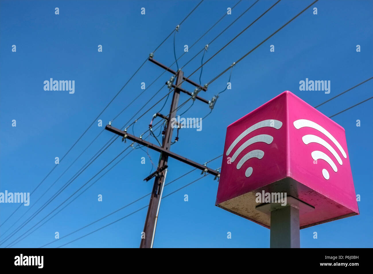 Les lignes de téléphone et une connexion Wi-Fi gratuite signe, contre un ciel bleu. Banque D'Images