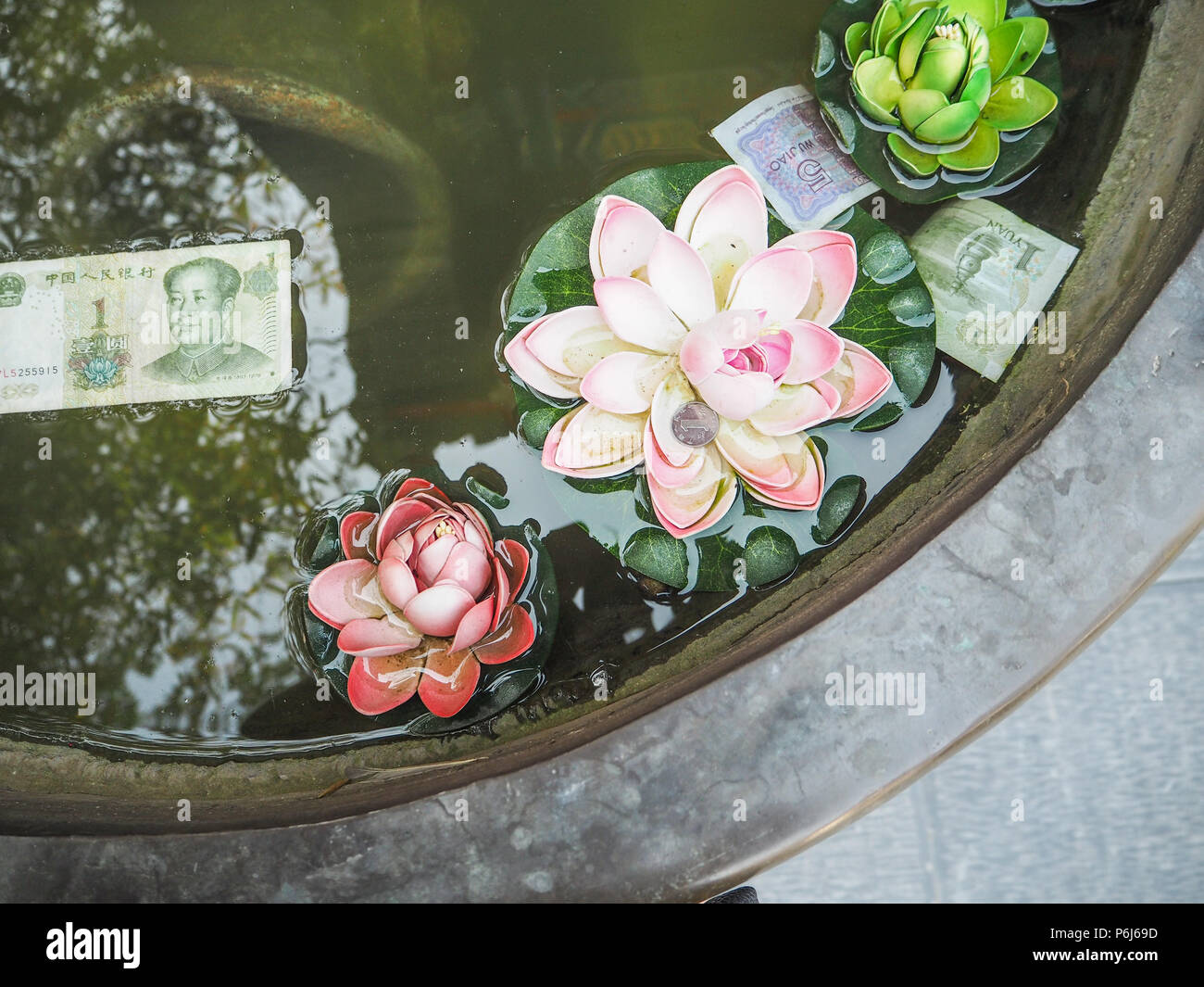 Fausses fleurs en plastique et de l'argent chinois flottant dans un grand désir de bronze électrique pour la prospérité Banque D'Images