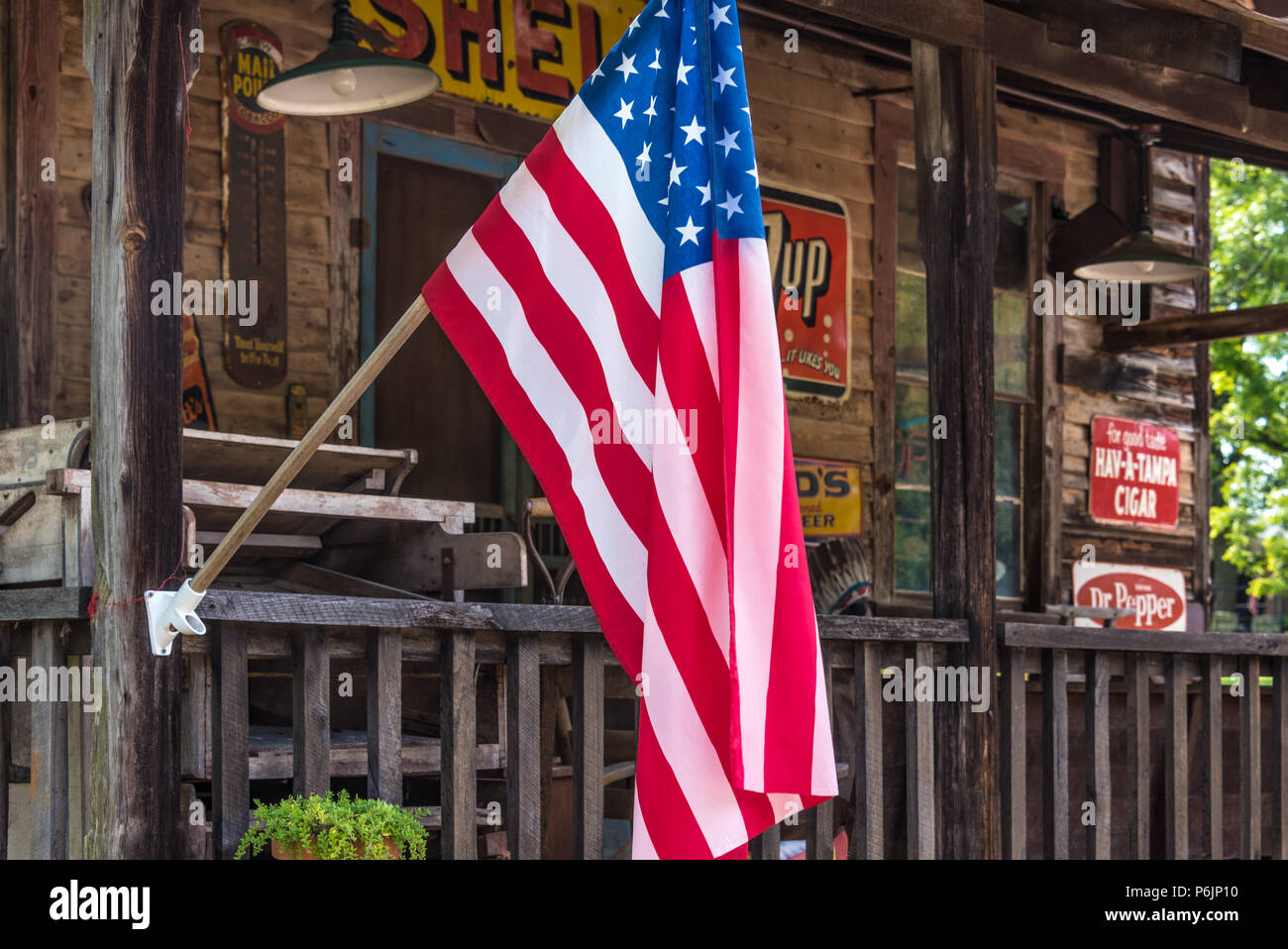Drapeau américain sur le porche d'une boutique d'antiquités dans les contreforts des Blue Ridge Mountains. (USA) Banque D'Images