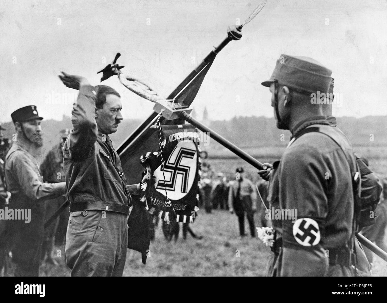 Adolf Hitler inaugure un drapeau du parti Nazi au cours d'un rassemblement du parti en Allemagne. Banque D'Images