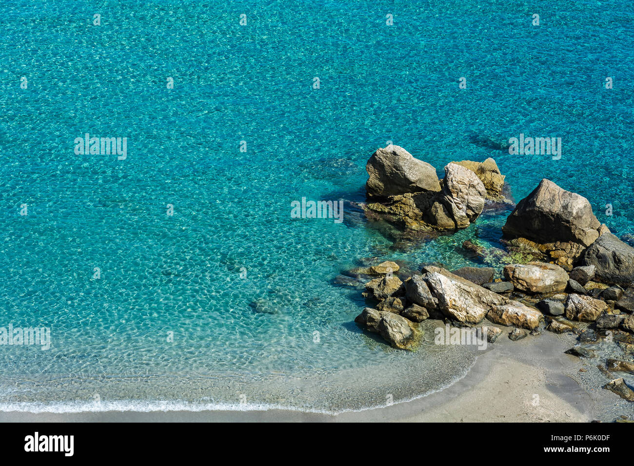 L'eau turquoise clair et propre sur la plage avec de petites pierres Banque D'Images