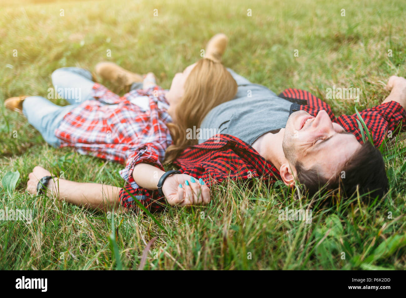 Couple élégant et moderne reste en vert de l'herbe sur la colline en arrière pays Banque D'Images