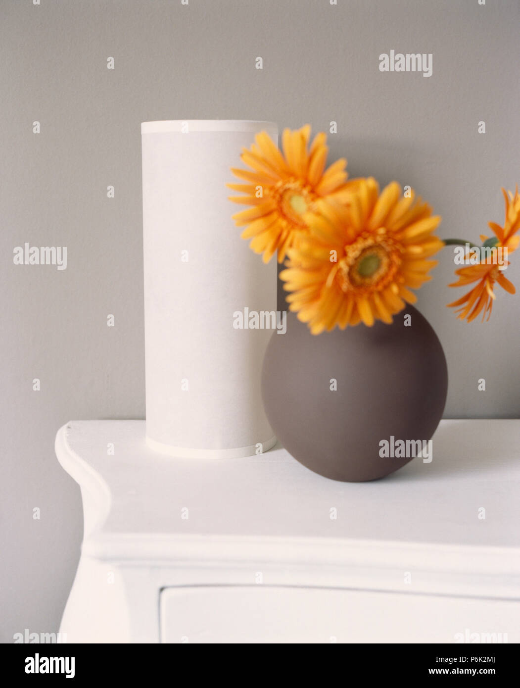 Still-Life d'orange dans les œillets sphériques gris vase à côté vase cylindrique blanc Banque D'Images