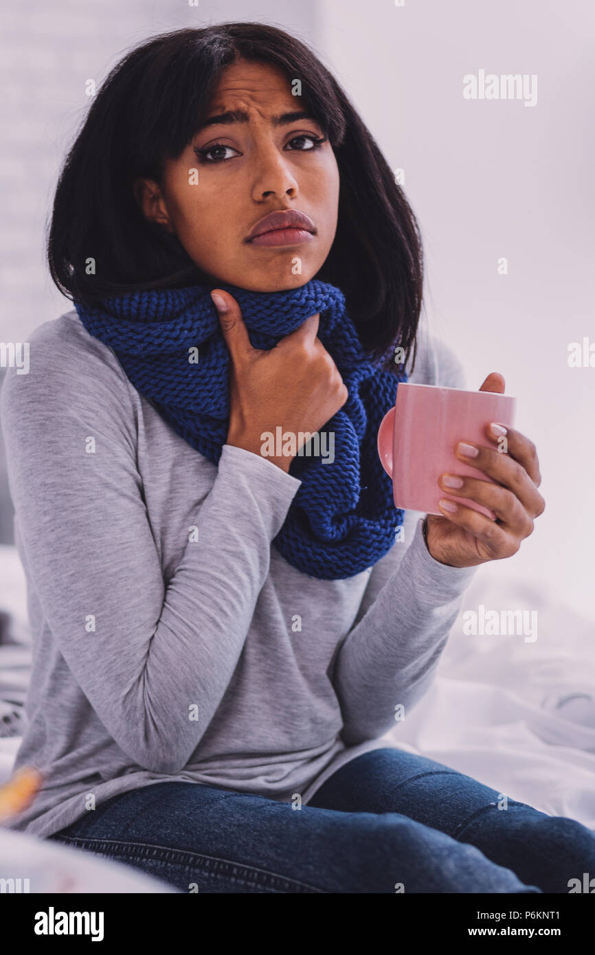 Femme malade personne couvrant son cou avec écharpe Banque D'Images