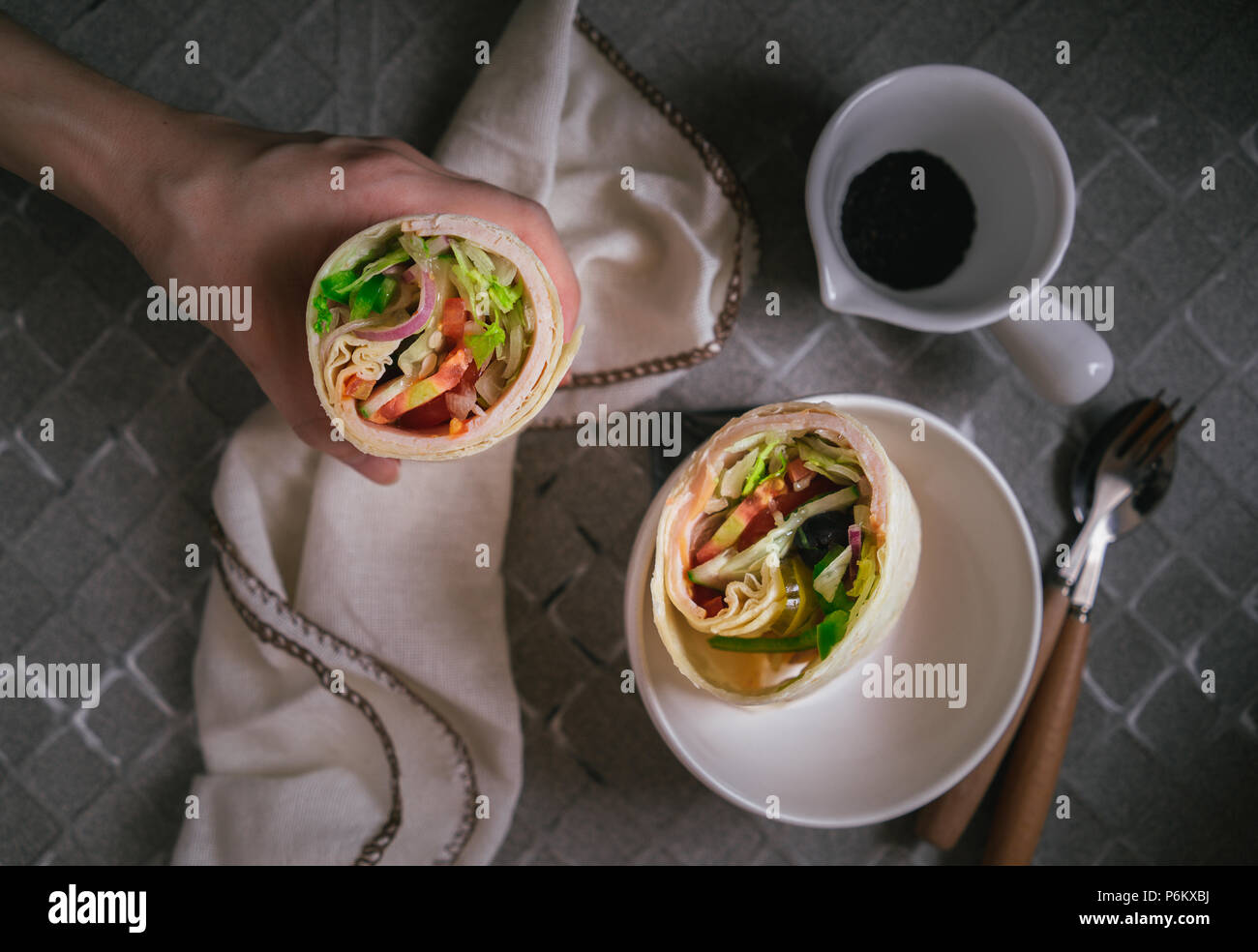 Hand Holding Wrap Sandwich, section transversale, tables Banque D'Images