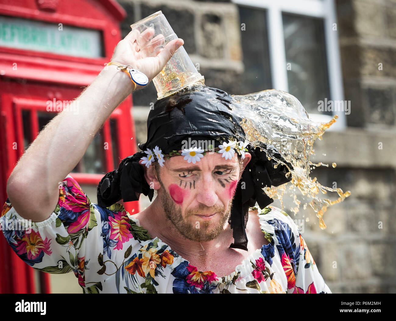 Concurrents prend part à la ferme de la course de la paille dans le Yorkshire, un 2,5 km course en robe portant une botte de paille de 20 kg, tout en arrêtant de pintes de bière le long de la route. Banque D'Images